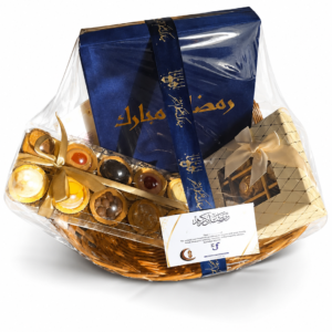 Ramadan corporate gift hamper in a wicker basket with a navy Ramadan Mubarak box, chocolates and a greeting card
