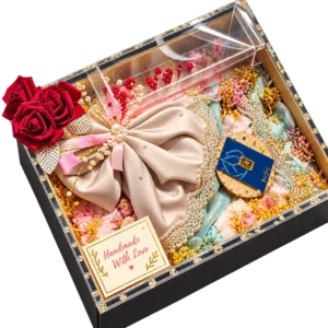 Black trousseau box with a clear acrylic lid, a satin bow bundle, dried flowers and red roses