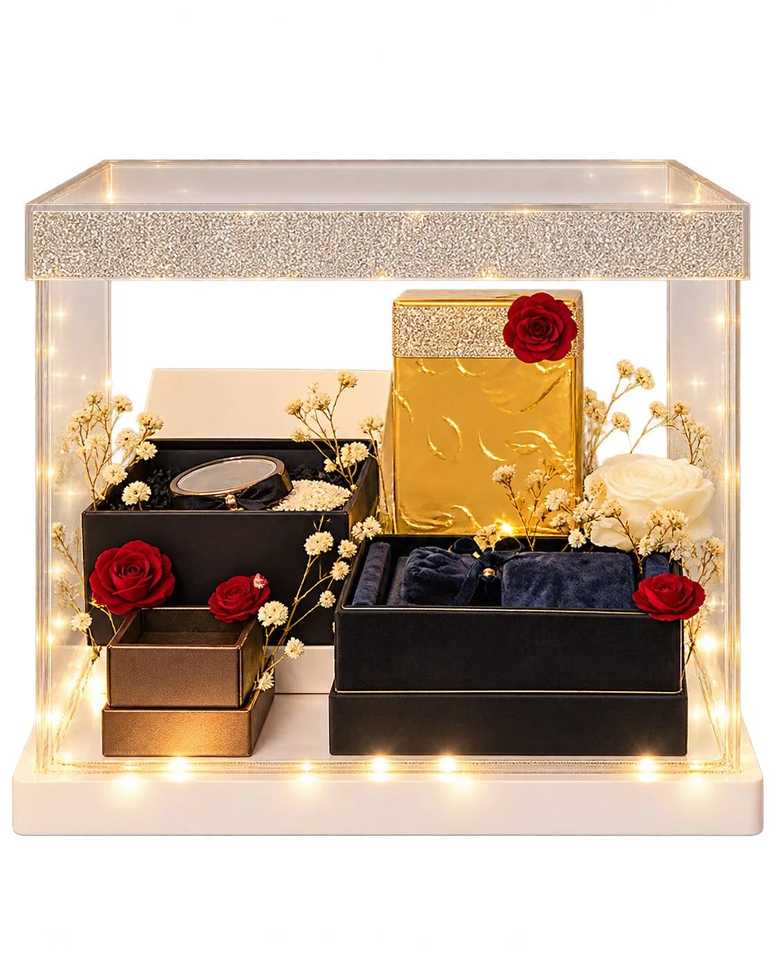 Clear acrylic display box with a crystal band and fairy lights, holding gift boxes, a gold box and red and white roses