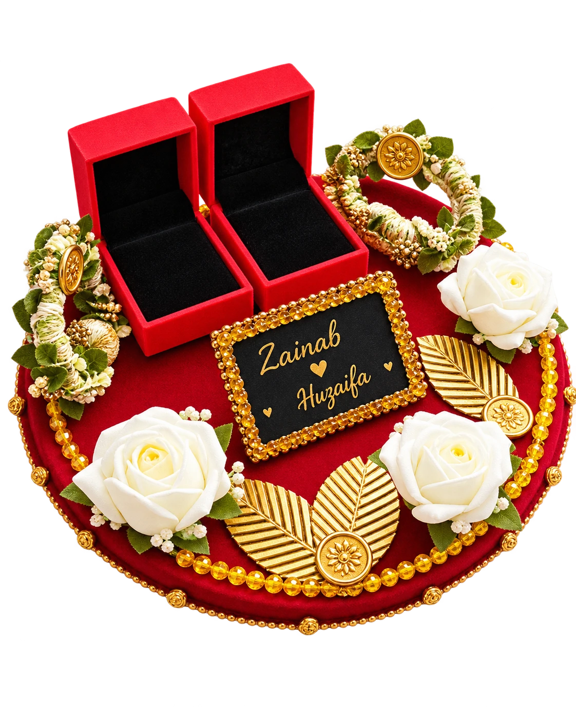 Round red velvet ring ceremony tray with two red ring boxes, gold leaves, white roses, gajra bracelets and a name plaque
